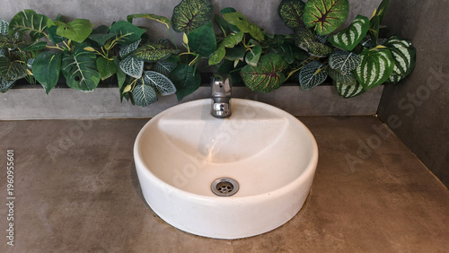Wallpaper Mural Modern bathroom basin surrounded by lush green plants and a minimalist concrete wall Torontodigital.ca