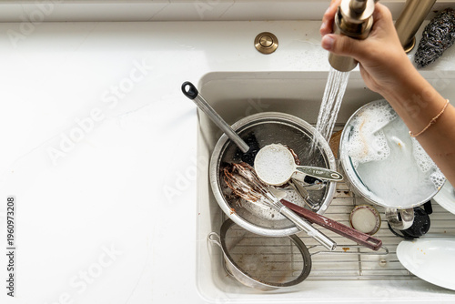 Overhead view of rinsing baking dishes in white farmhouse kitchen sink