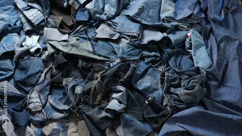 Pile of denim fabric scraps left after clothing production. Concept of textile waste, denim recycling, sustainable fashion and environmental responsibility