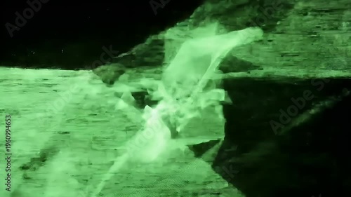 A green-lit astronaut exploring a rocky lunar surface with a spacecraft