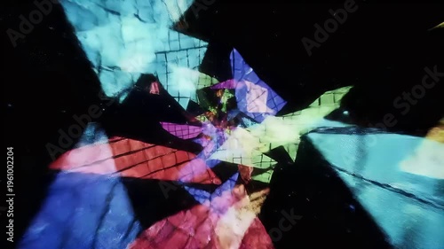Vibrant colorful geometric shapes intersect and overlap in a dark abstract scene with light reflections.