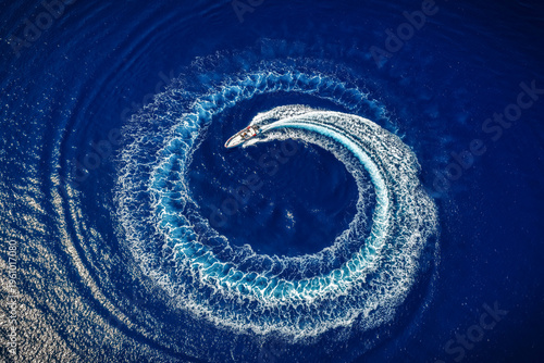Fotografía High aerial overhead view of a motor RIB boat forming a circle of bubbles and su