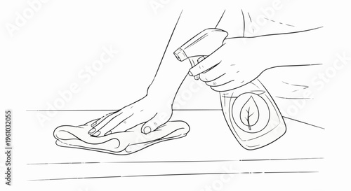 Hand cleaning a surface with a spray bottle and cloth
