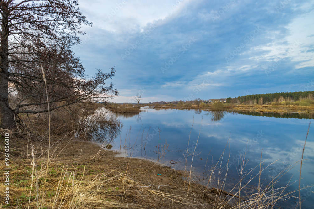 Obraz premium Silent lake mirrors blue sky and distant trees