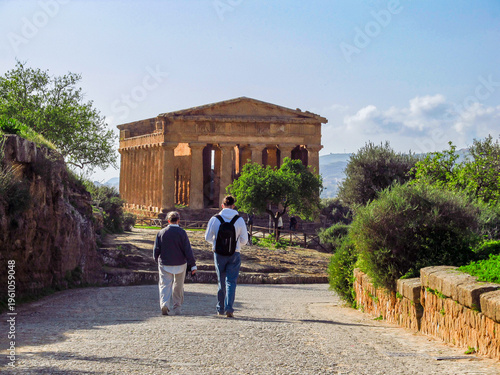 Fotografie Couple walking toward the Temple of Concordia, discussing history and sharing a meaningful travel experience in the Valley of the Temples