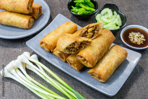 Fotografia Indonesian Lumpia Semarang fried spring rolls on a grey plate with dipping sauce