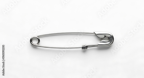 A silver safety pin on a white background