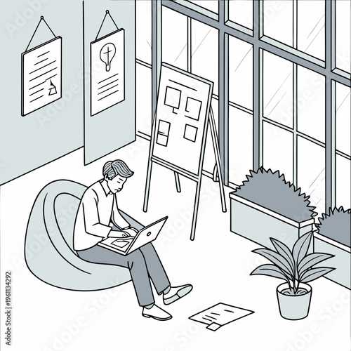 A man sitting on a bean bag chair working on a laptop