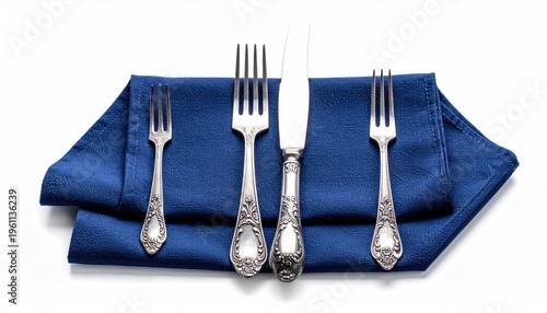 Silverware on a blue cloth against a white background, overhead view