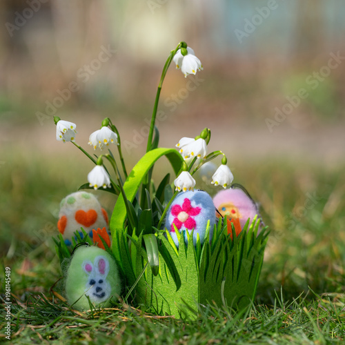 green basket with colorful felted eggs for easter party