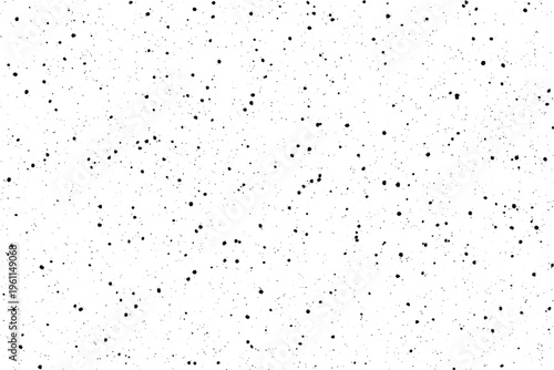 A multitude of small irregular black spots are dispersed over a stark plain white field creating a grainy texture