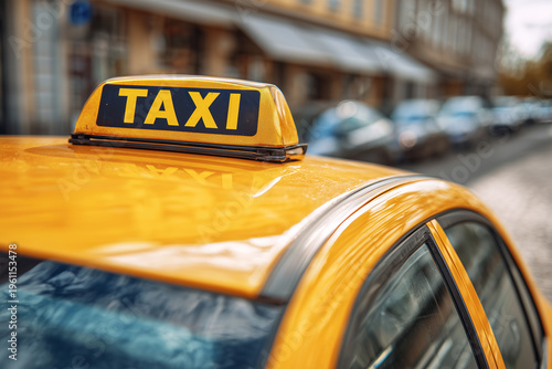 Taxi on city street with parked cars nearby in bright sunlight