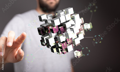 A person's hand interacting with a 3D cube, representing concepts like technology, innovation, and digital transformatio