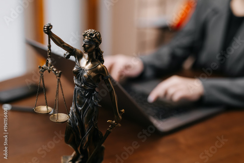 Fotografie Professional female lawyer at desk with Lady Justice statue