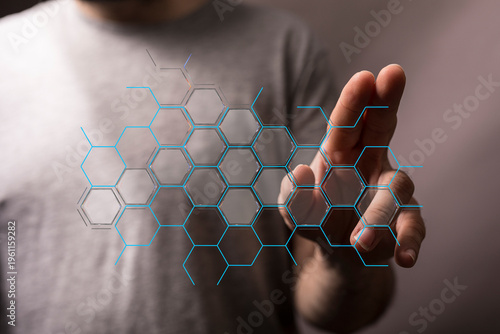 Abstract technology concept featuring a hand touching a network of hexagonal data points. Illustrating connectivity, inn