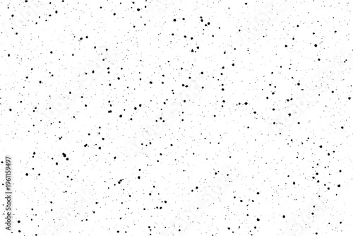 Numerous tiny black dots are scattered randomly across a bright white surface creating a subtle textured appearance