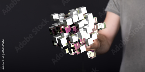 A close-up shot of a person holding a digital cube, a concept of technology, innovation, and futuristic design. Dark bac