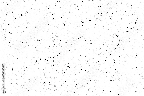 Numerous tiny dark particles are randomly dispersed creating a subtle speckled texture across a bright area