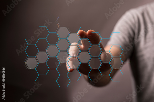 Abstract image of a hand interacting with a virtual digital interface, hexagons. Represents futuristic innovation, conne