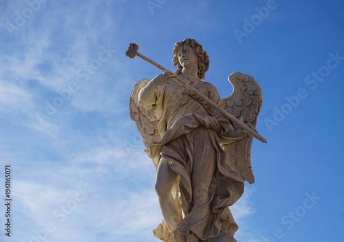Fotografie A beautiful marble statue of an angel with a sponge on a stick depicts a biblical scene from the crucifixion on Ponte Sant'Angelo, the historic angel bridge in Rome, Italy