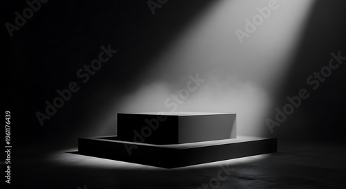 A two-tiered, box-shaped platform, dramatically lit from above against a black background