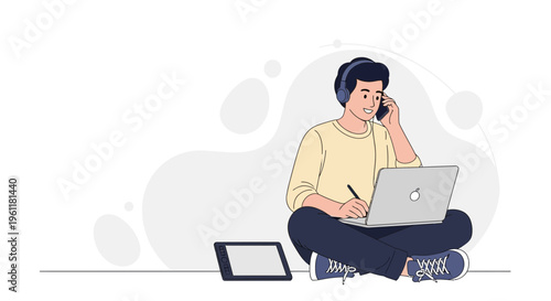 Young man working remotely with laptop and phone, wearing headphones, sitting on floor