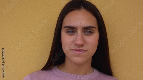Happy teenager girl smiling on camera with yellow background - Young woman, back to school and campus lifestyle concept