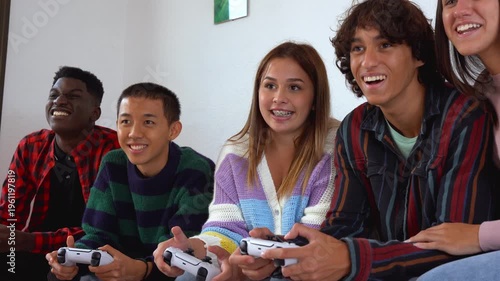 Happy teenager friends having fun playing video games at home - Group of young multiracial people, lifestyle and leisure day concept 