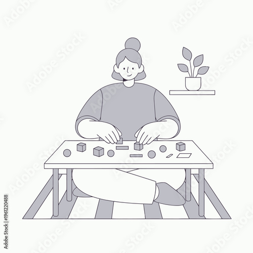 Woman engrossed in building with wooden blocks at table.