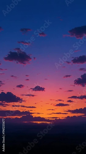 Vibrant orange, pink, and purple sunset with scattered clouds over horizon