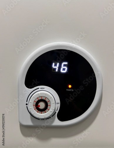 Tableau sur toile Female hand adjusting a home heating thermostat