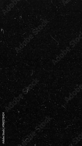 Vintage cinematic film dust and scratches overlay on black background vertical video. Retro 8mm noise texture light leak for antique aesthetic video transitions and effects.
