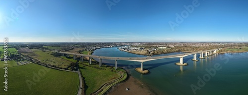 Aerial view of the Orwell Bridge, a concrete and steel structure spanning the tranquil blue waters under a clear sky, Orwell Bridge, Ipswich, United Kingdom.