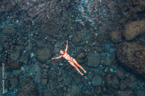 Obraz na plátně Aerial View of Solitary Female Swimmer in Turquoise Volcanic Natural Pool, El Hi