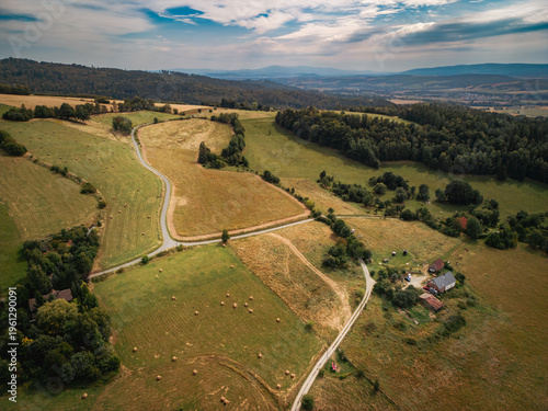 Aerial view of Sudetes mountains landscape in Poland. Scenic countryside, rolling hills with hay bales and rural farm.