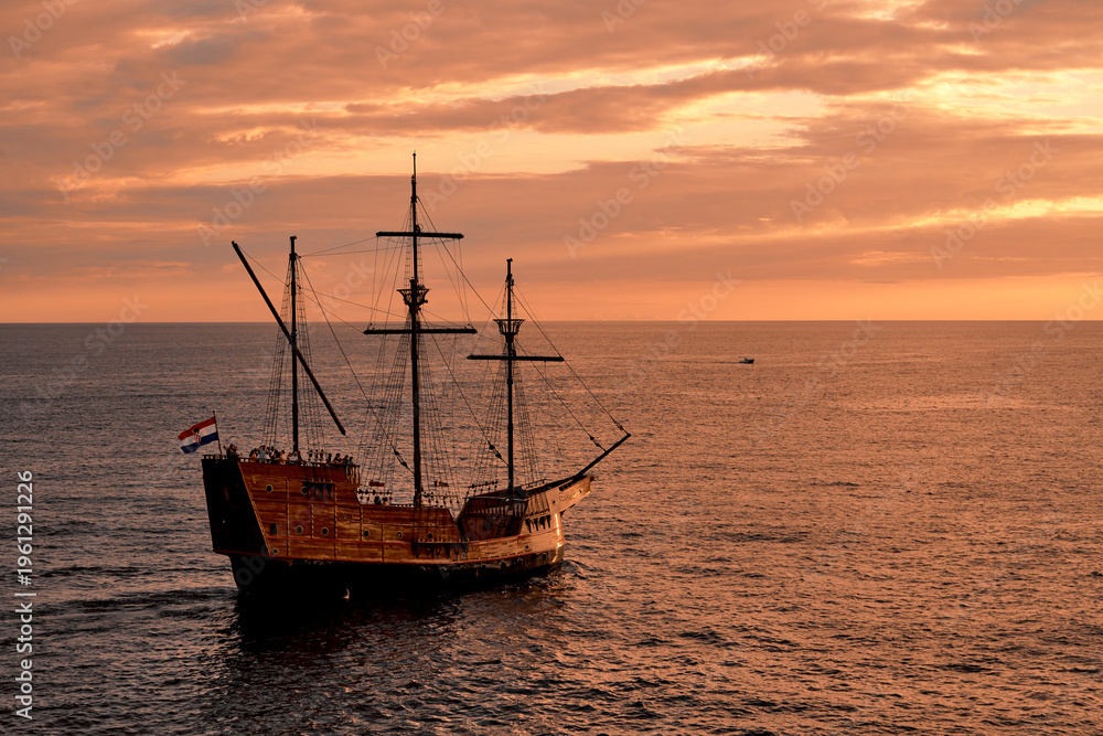 Obraz premium Viejo barco navegando en el mar en el atardecer