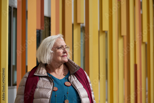 Mujer senior mira el horizonte en la ciudad con fondo arquitectonico