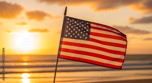American flag waving on independence day at sunset beach
