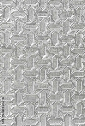 Imagem de fundo formada por um painel de metal com iscrições em letra árabe.