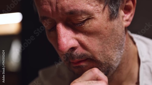 Restless adult man sitting in silence, leaning on hand, showing tired and uneasy facial expression in closeup portrait, procrastination concept. 4K