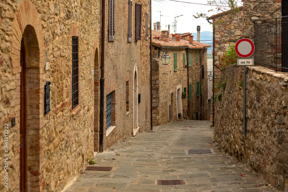 Fototapeta premium Charming street winding uphill in medieval Castiglione d'Orcia, Tuscany, Italy.