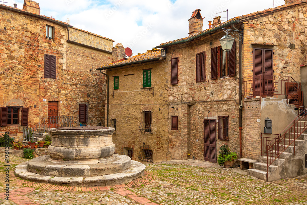 Fototapeta premium Castiglione d'Orcia historic well and ancient stone buildings, Tuscany, Italy.