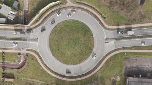 Genk, Belgium. Top-down drone hoovering over busy roundabout with flowing traffic and transport vehicles