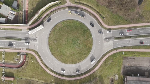 Genk, Belgium. Top-down drone hoovering over busy roundabout with flowing traffic and transport vehicles