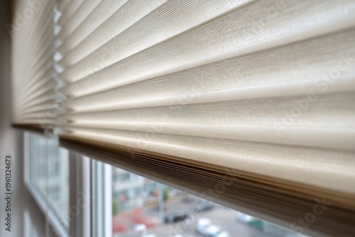 Close-up of beige pleated blinds installed in an interior window opening with soft daylight