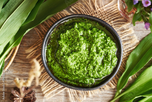 Pesto made of wild garlic or ramson leaves in a black bowl, top view