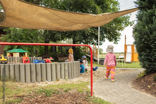 Obraz na płótnie Kindergartenkinder spielen draußen auf dem Spielplatz.