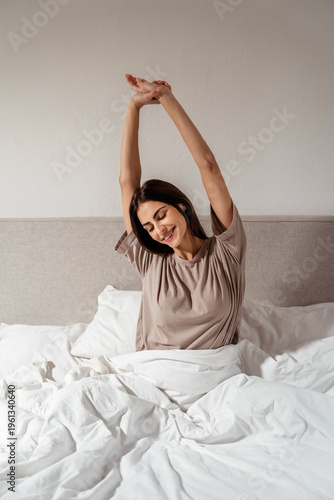 Happy woman stretching in bed after waking up, morning routine and healthy lifestyle