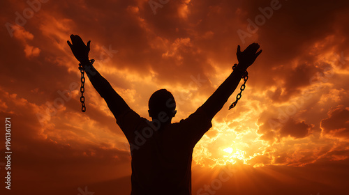 Silhouette of a man with arms raised to a dramatic sunset sky, signifying freedom, hope, release, spiritual awakening, overcoming adversity, and new beginnings