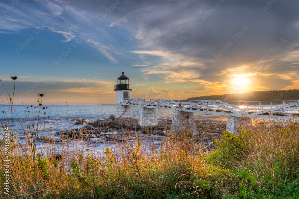 Fototapeta premium Marshall Point Lighthouse at Sunset Over Shoreline Weeds
